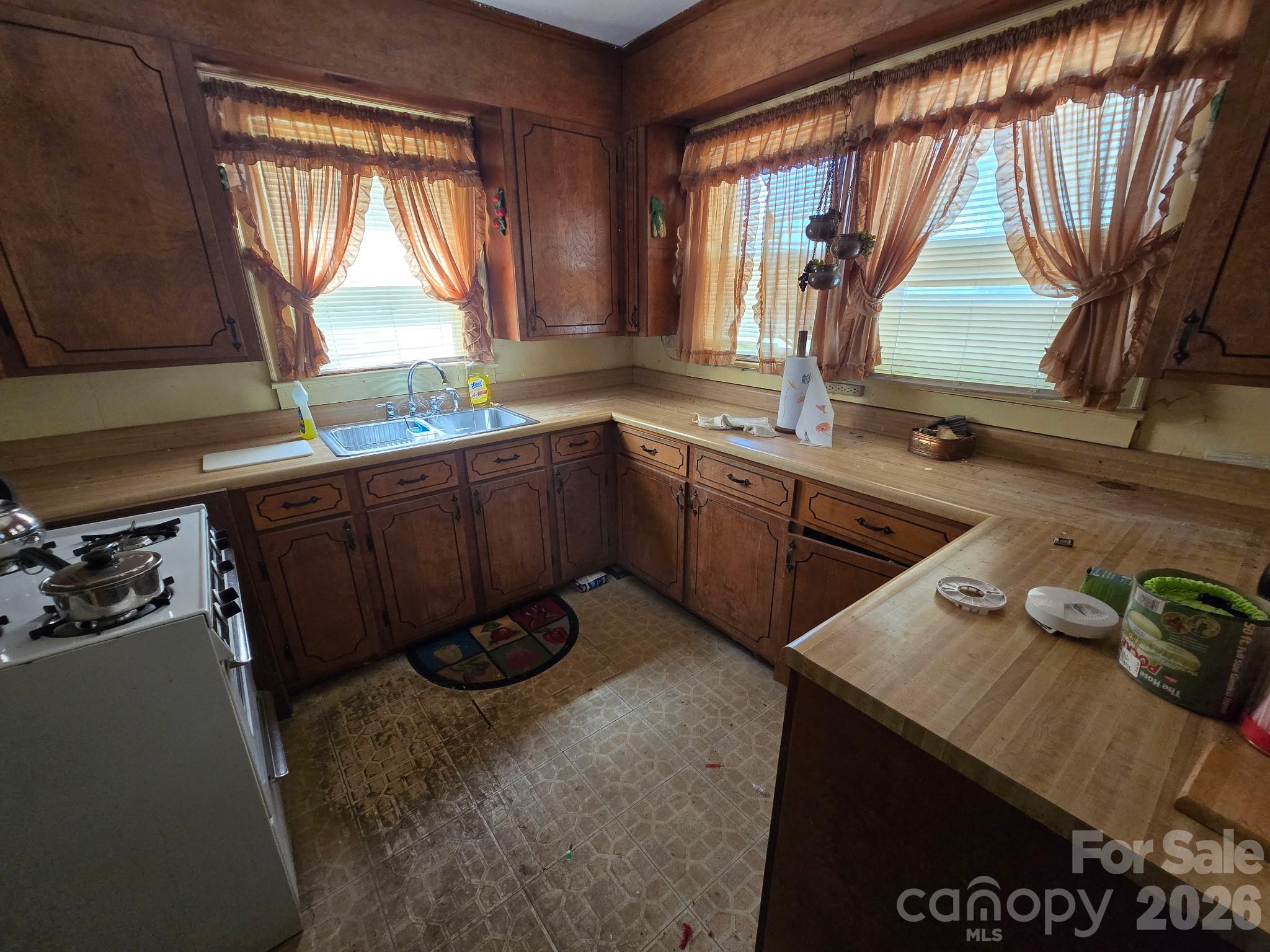 840 Skinner Road Shelby, NC 28152 - Photo 11 of 22 a kitchen with stainless steel appliances wooden cabinets a stove a sink and a large window