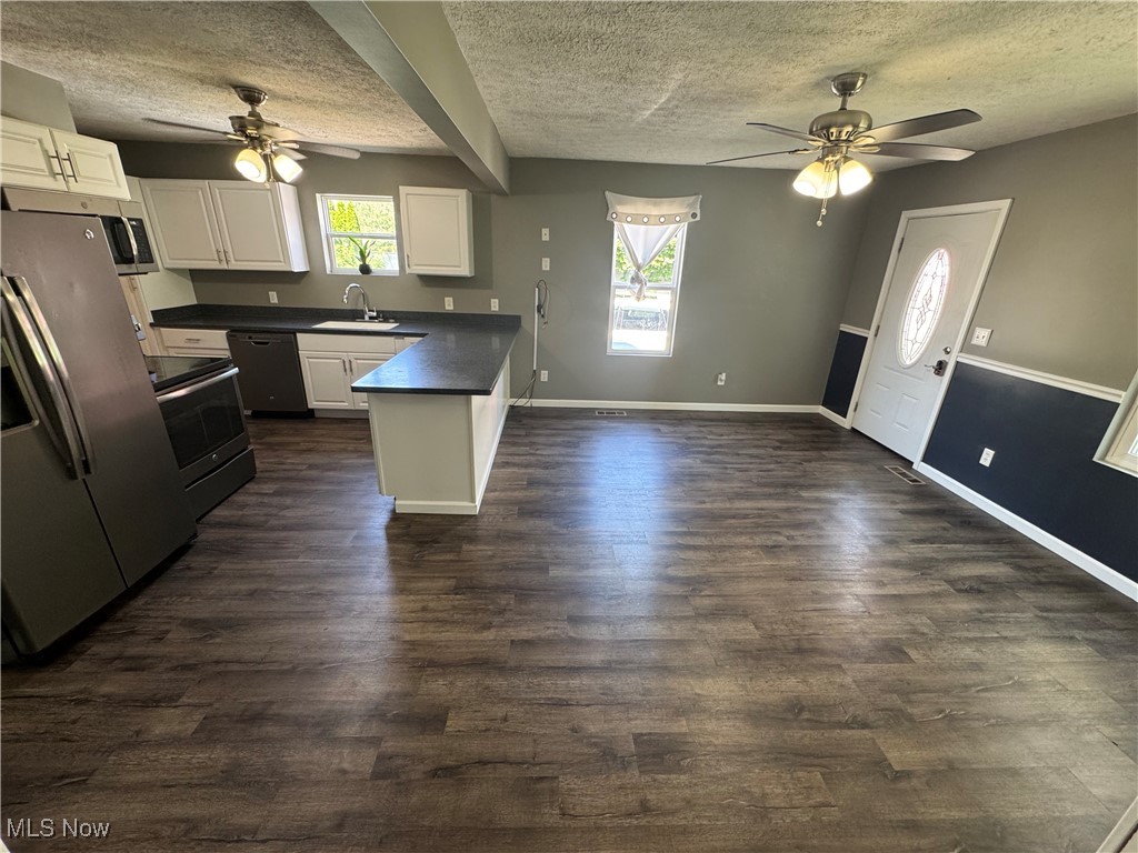2660 Ridge Road Zanesville, OH 43701 - Photo 10 of 20 Kitchen with a textured ceiling, a ceiling fan, dark countertops, a peninsula, and appliances with stainless steel finishes