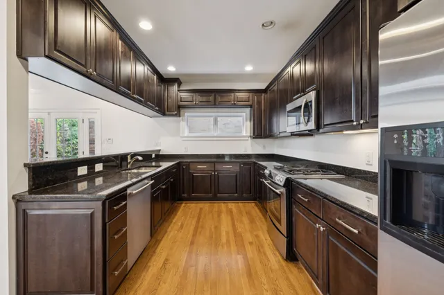 a kitchen with stainless steel appliances granite countertop a stove and a sink
