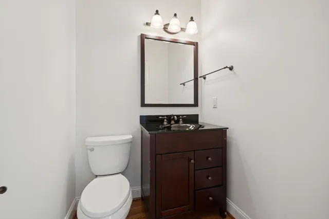 a bathroom with a toilet sink and mirror
