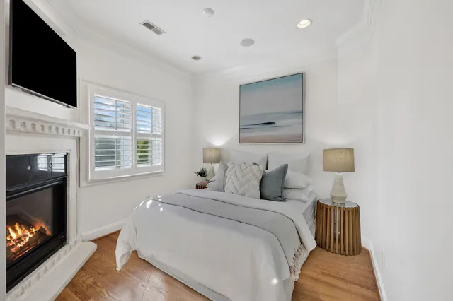 a bedroom with a bed a flat screen tv and a fireplace
