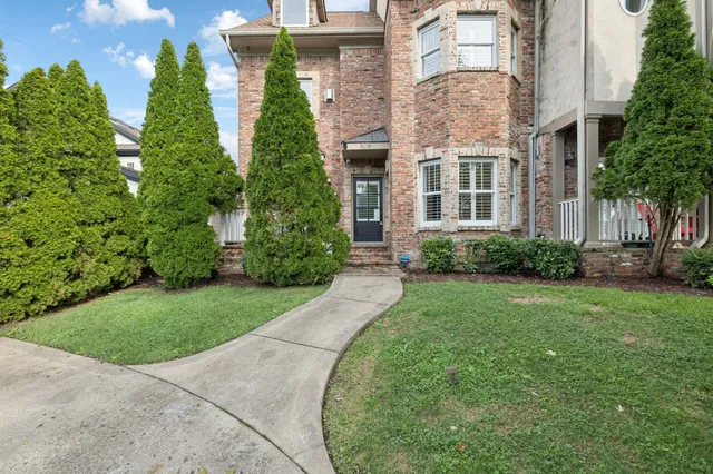 front view of a brick house with a yard