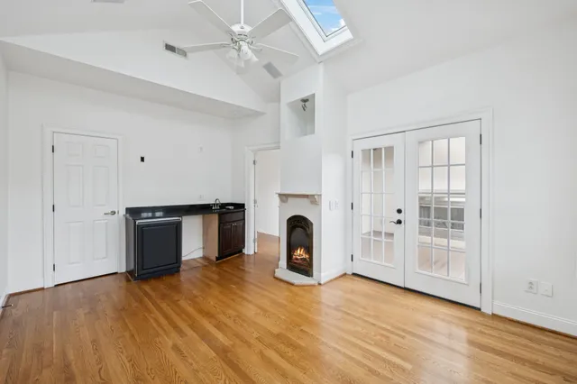 a view of a room with wooden floor a fireplace and windows