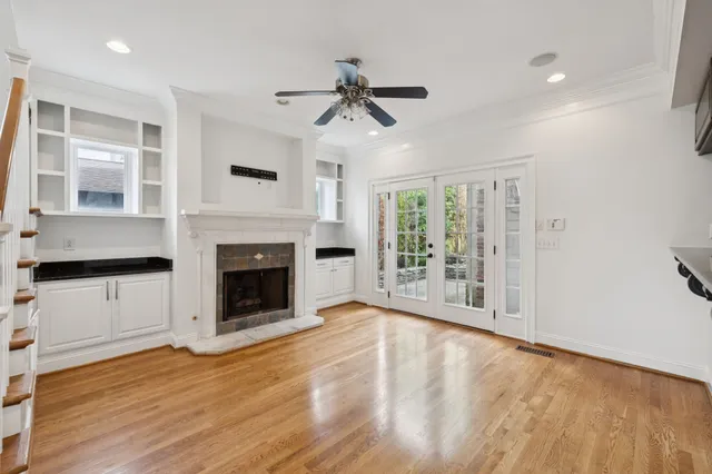 a view of a livingroom with a fireplace wooden floor and windows