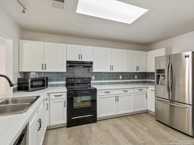 a kitchen with cabinets stainless steel appliances and a sink