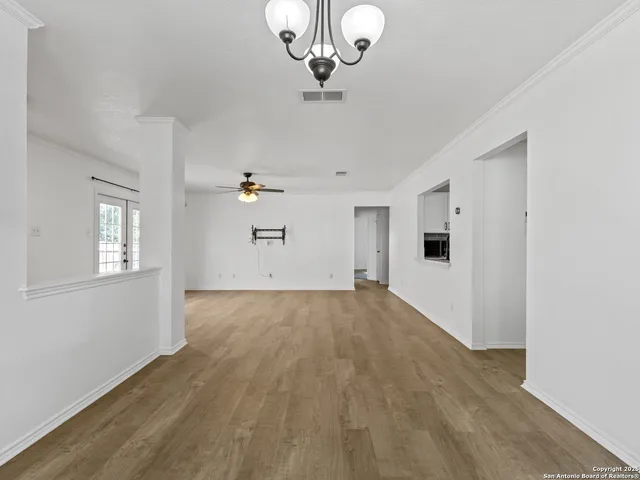a view of empty room with wooden floor
