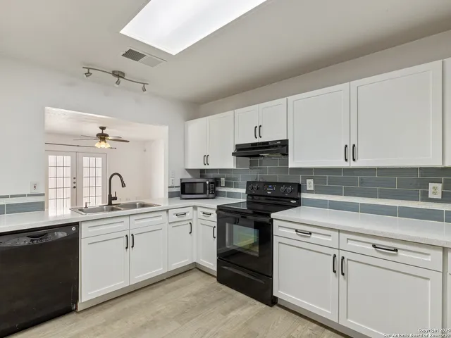 a kitchen with cabinets appliances a sink and a counter top space
