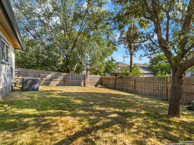 a view of a yard with a house and large tree
