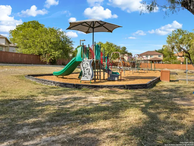 a view of a swimming pool with a bench and lawn chairs under an umbrella