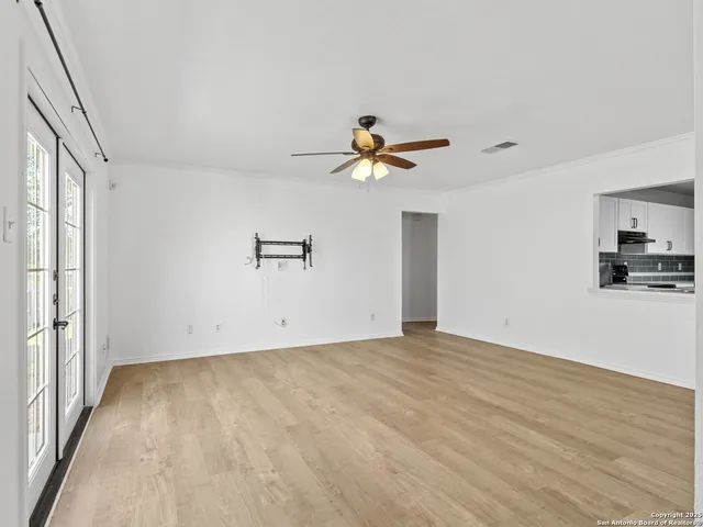 a view of a room with wooden floor and a ceiling fan