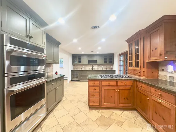 a kitchen with stainless steel appliances granite countertop a stove top oven microwave and cabinets