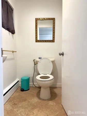 a view of a hallway with wooden floor and a bathroom