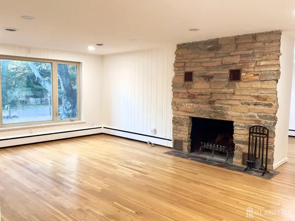 a view of an empty room with a fireplace and a window