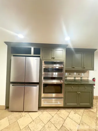 a kitchen with stainless steel appliances granite countertop a refrigerator and a sink
