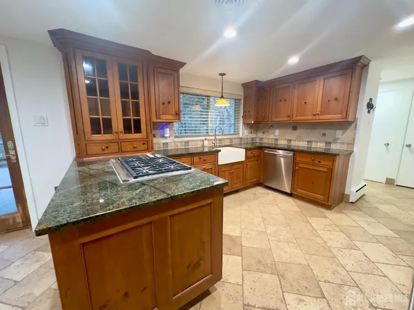 a kitchen with stainless steel appliances granite countertop a stove a sink and a microwave