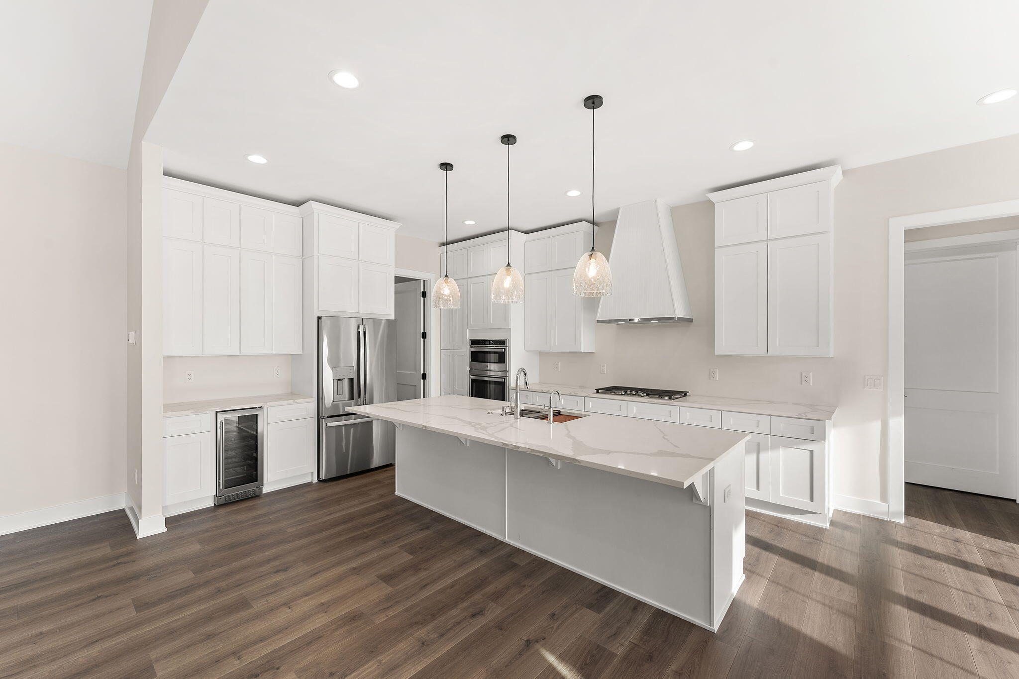 16669 Noble Street Lowell, IN 46356 - Photo 14 of 55 a large kitchen with stainless steel appliances kitchen island granite countertop a refrigerator a sink dishwasher a stove and white cabinets with wooden floor