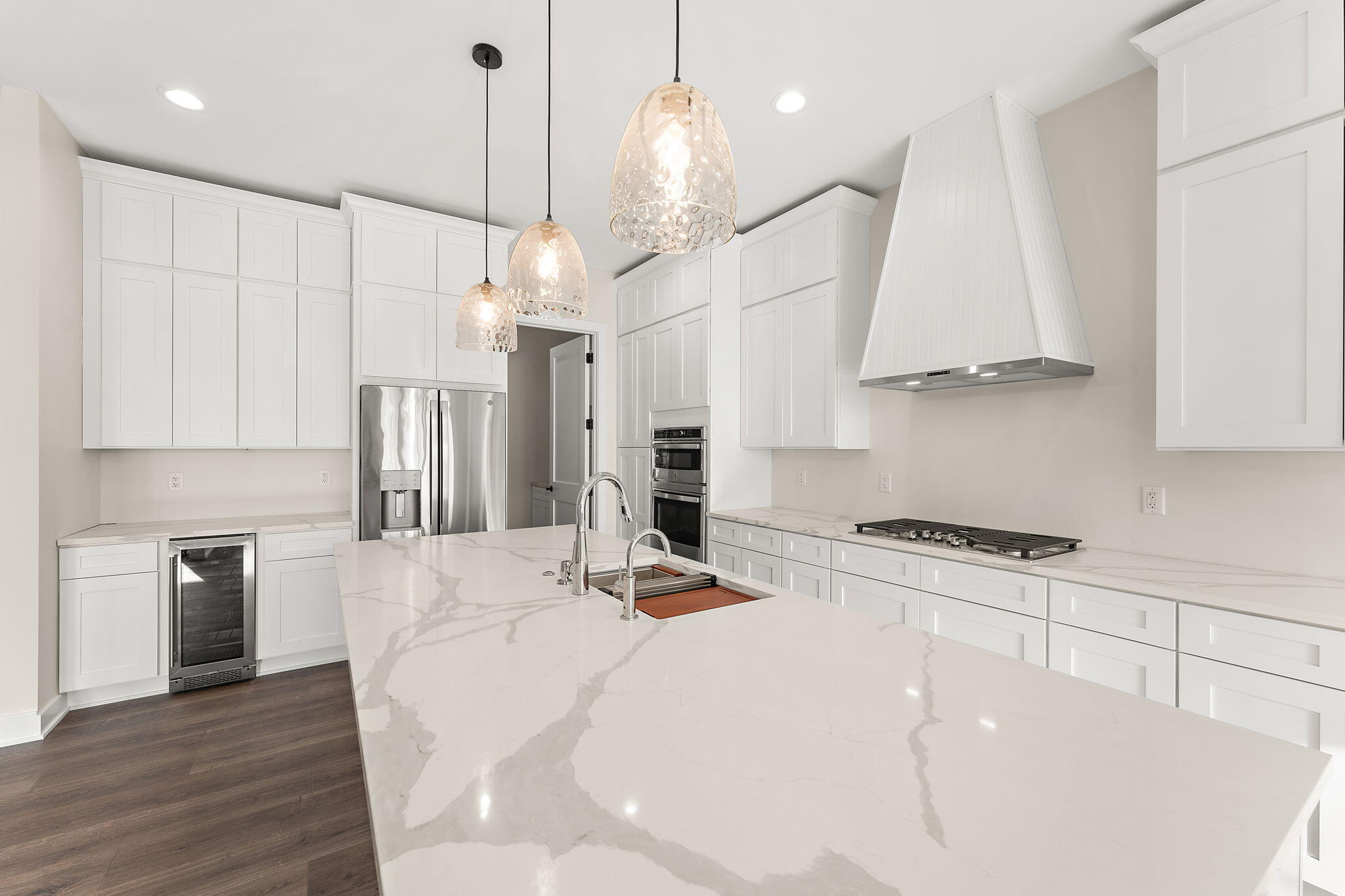 16669 Noble Street Lowell, IN 46356 - Photo 17 of 55 a kitchen with stainless steel appliances kitchen island granite countertop a stove a sink a refrigerator and white cabinets with wooden floor