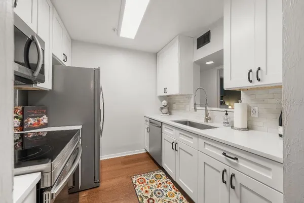 a kitchen with stainless steel appliances granite countertop a sink stove and cabinets