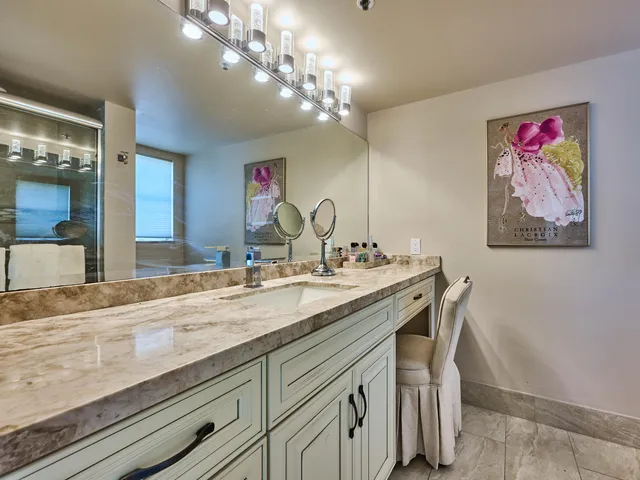 a bathroom with a granite countertop sink a large mirror and vanity