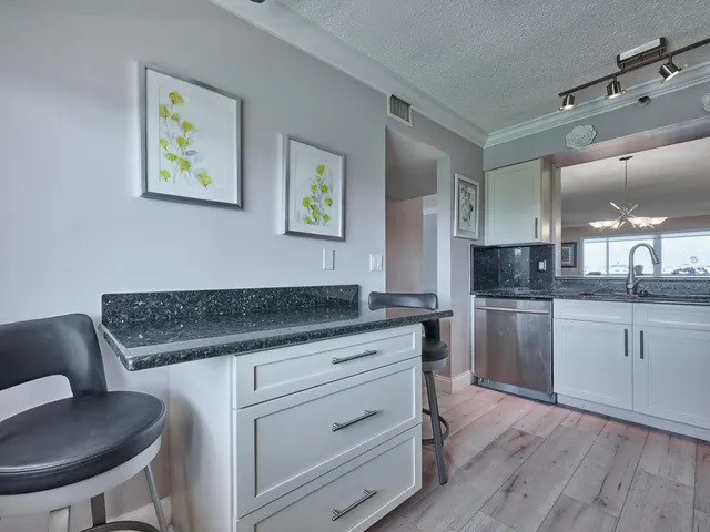 a kitchen with granite countertop a sink cabinets and wooden floor