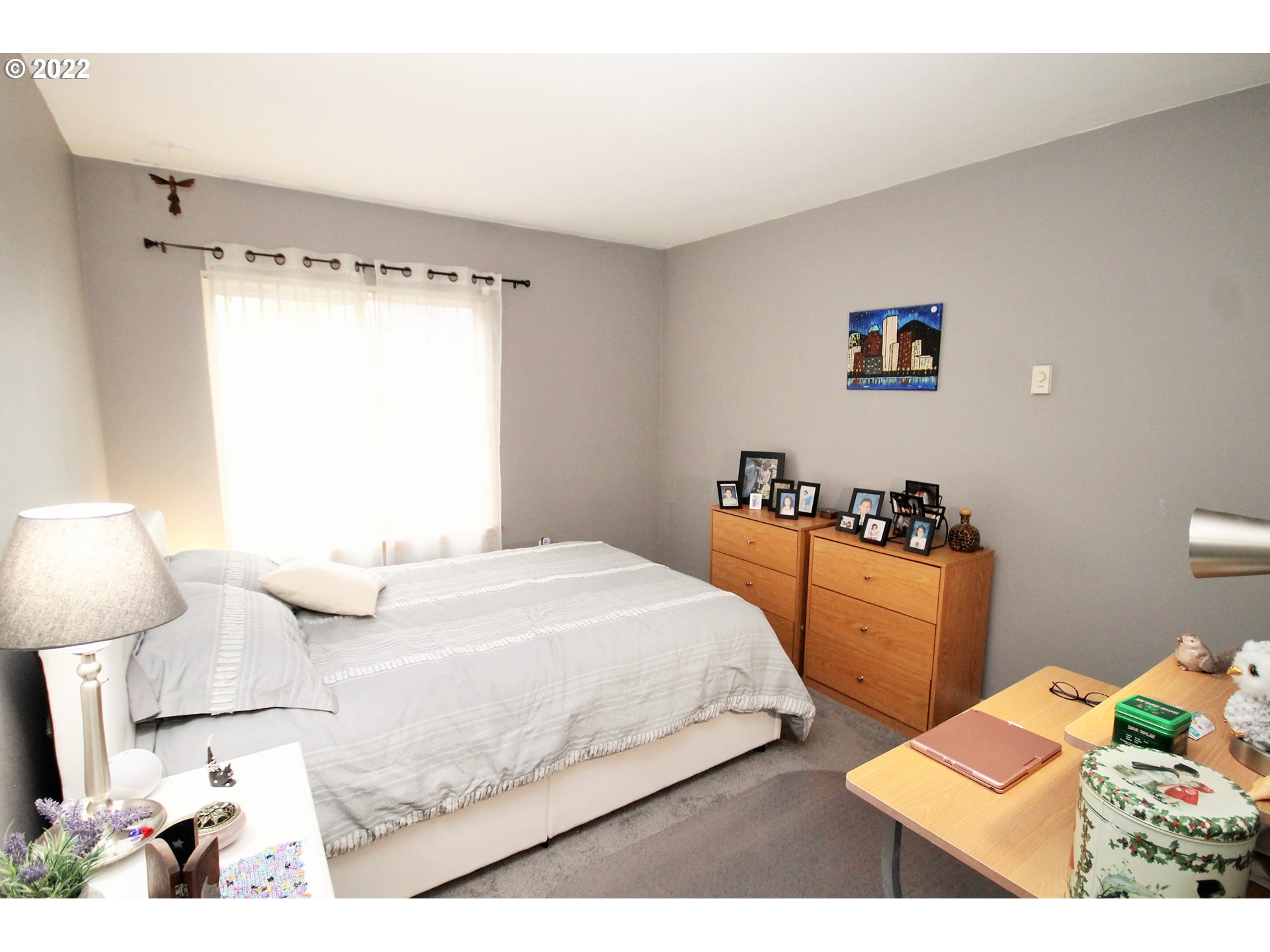 8720 Southwest Tualatin Road, Unit 107 Tualatin, OR 97062 - Photo 19 of 30 a bedroom with a bed and a lamp on dresser