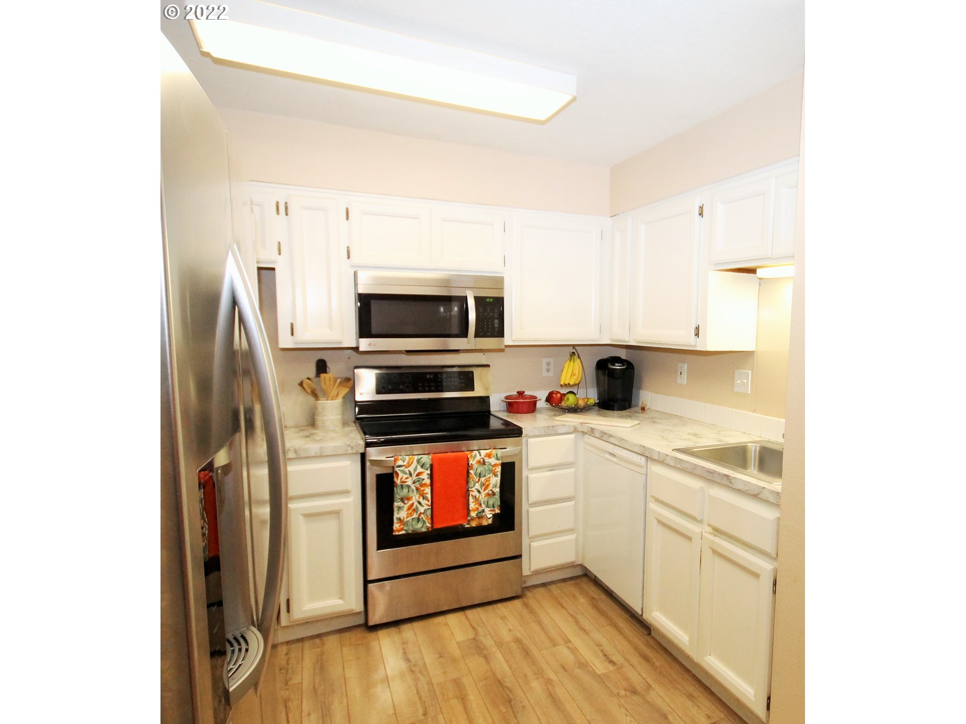 8720 Southwest Tualatin Road, Unit 107 Tualatin, OR 97062 - Photo 4 of 30 a kitchen with stainless steel appliances a stove a sink and white cabinets