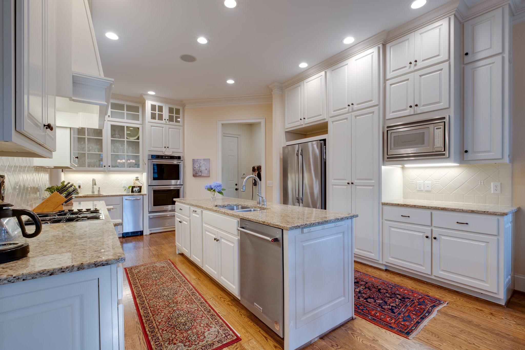 217 Page Road Nashville, TN 37205 - Photo 16 of 61 a kitchen with stainless steel appliances granite countertop a refrigerator oven a sink dishwasher and white cabinets with wooden floor