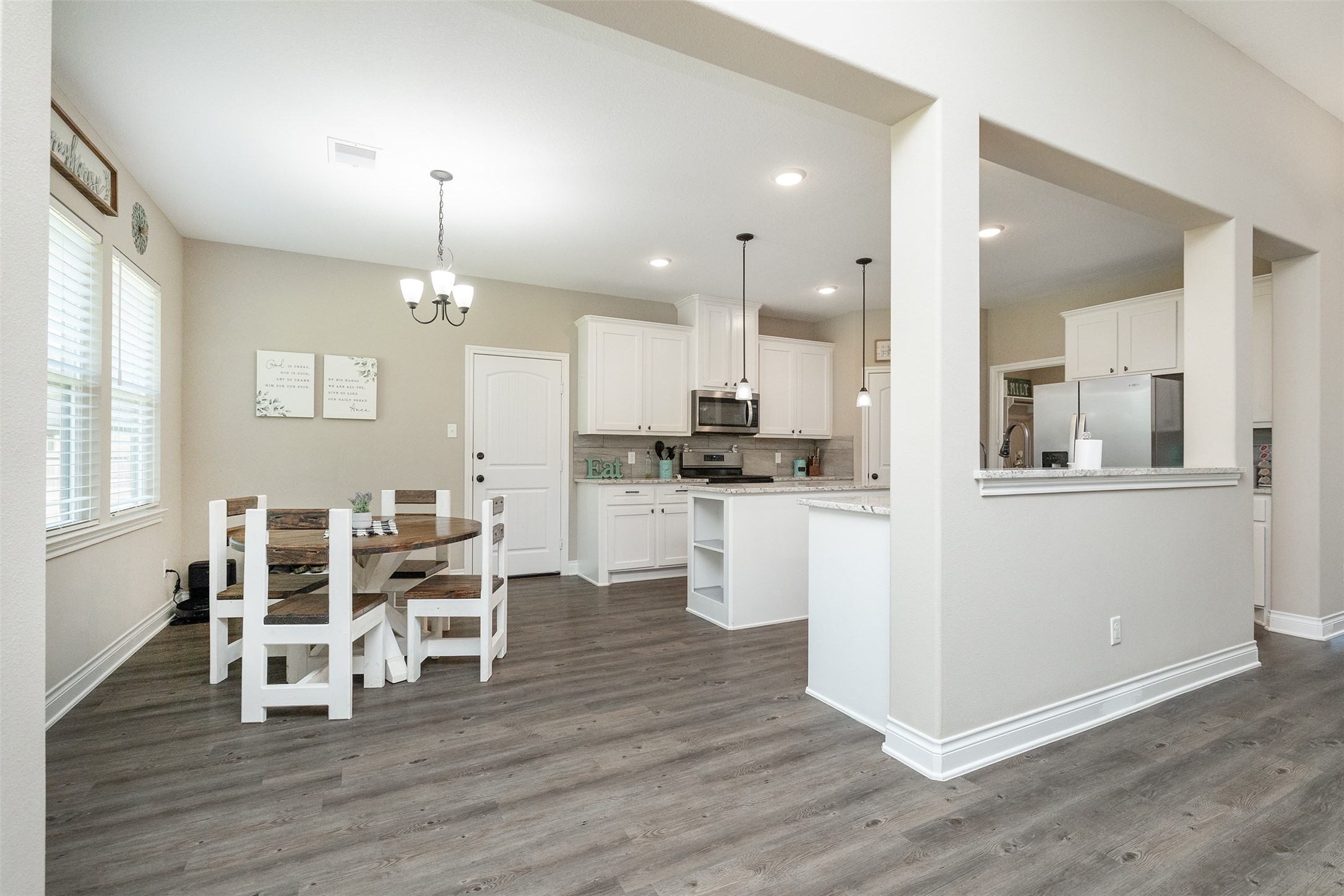 27627 Concho Drive Splendora, TX 77372 - Photo 12 of 41 a kitchen with stainless steel appliances kitchen island wooden floors and white cabinets