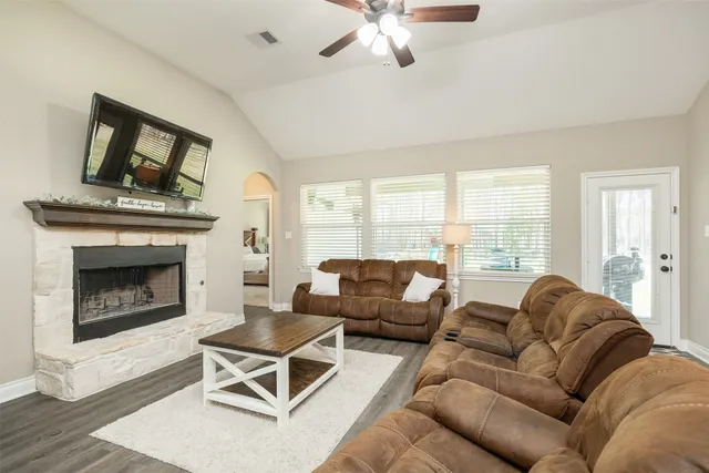a living room with furniture a large window and a fireplace