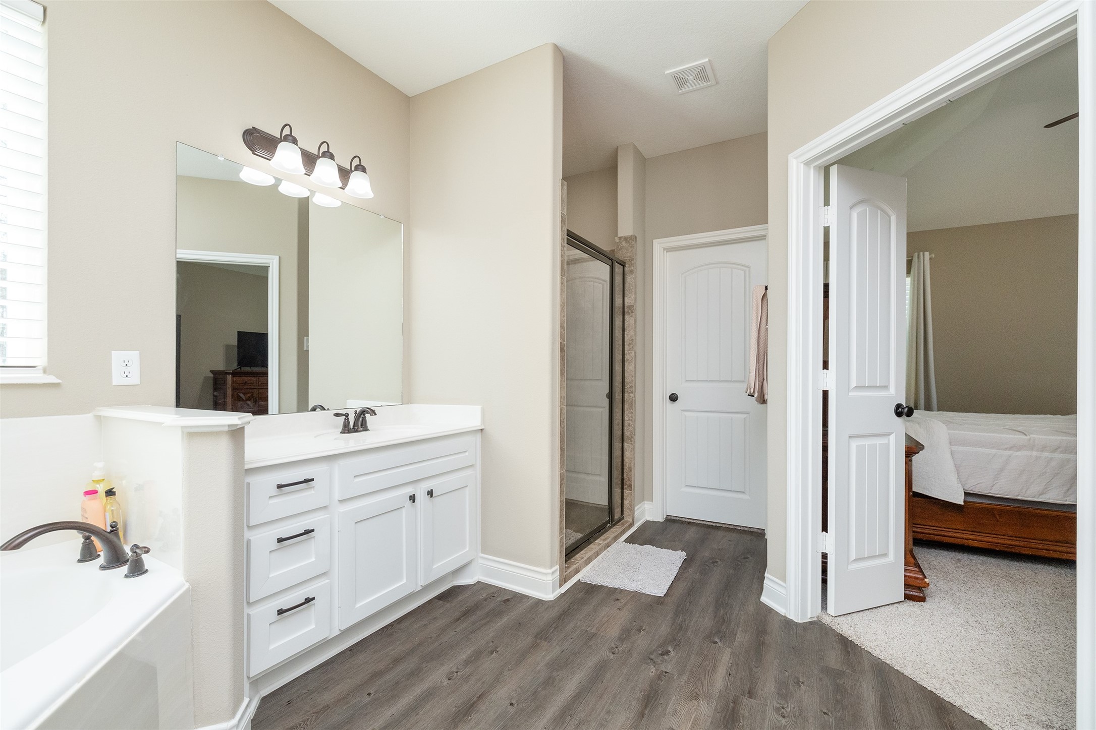 27627 Concho Drive Splendora, TX 77372 - Photo 24 of 41 a bathroom with a double vanity sink a mirror and a shower