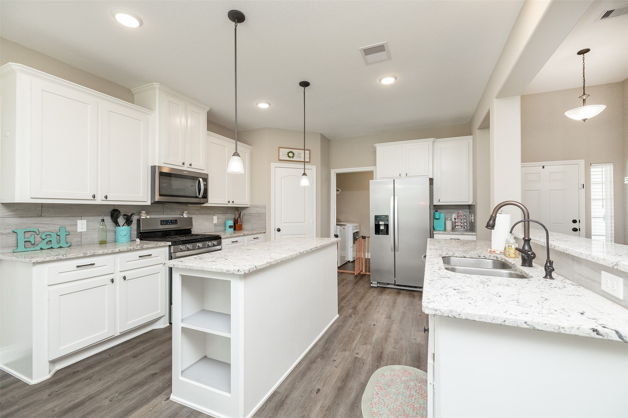27627 Concho Drive Splendora, TX 77372 - Photo 8 of 41 a kitchen with kitchen island a sink a stove and cabinets