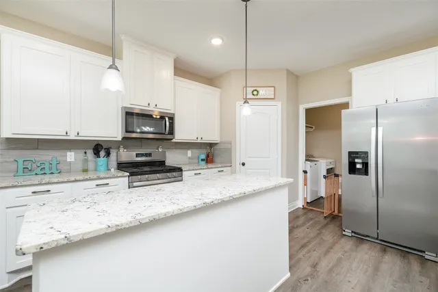 a kitchen with stainless steel appliances granite countertop a sink a refrigerator a stove a microwave and wooden floor