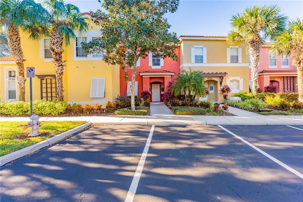 a front view of a house with a yard and palm trees