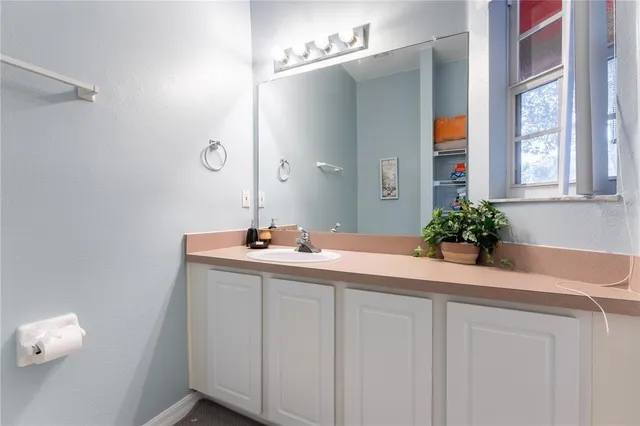 a white toilet sitting next to a bathroom sink and vanity