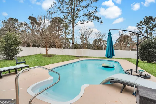 a view of a house with backyard and sitting area