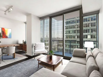 a living room with furniture and a floor to ceiling window