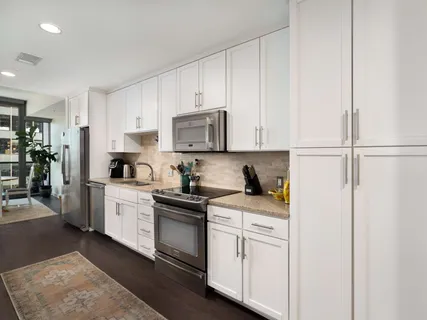 a kitchen with white cabinets and white appliances