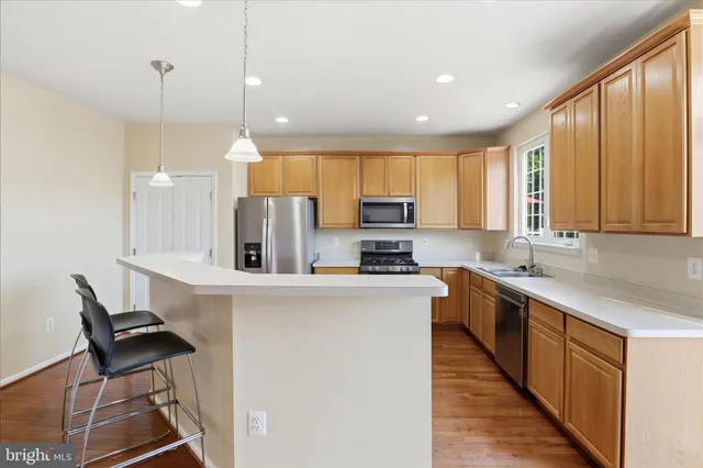 a kitchen with stainless steel appliances granite countertop a refrigerator a stove top oven a sink and dishwasher