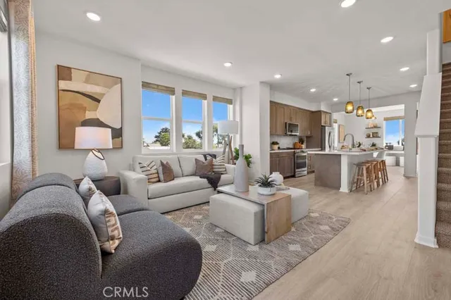 a living room with furniture and a view of kitchen