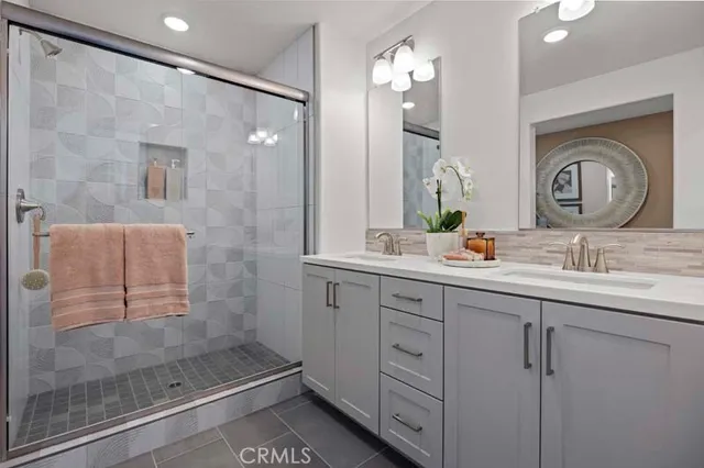 a bathroom with a double vanity sink mirror and shower