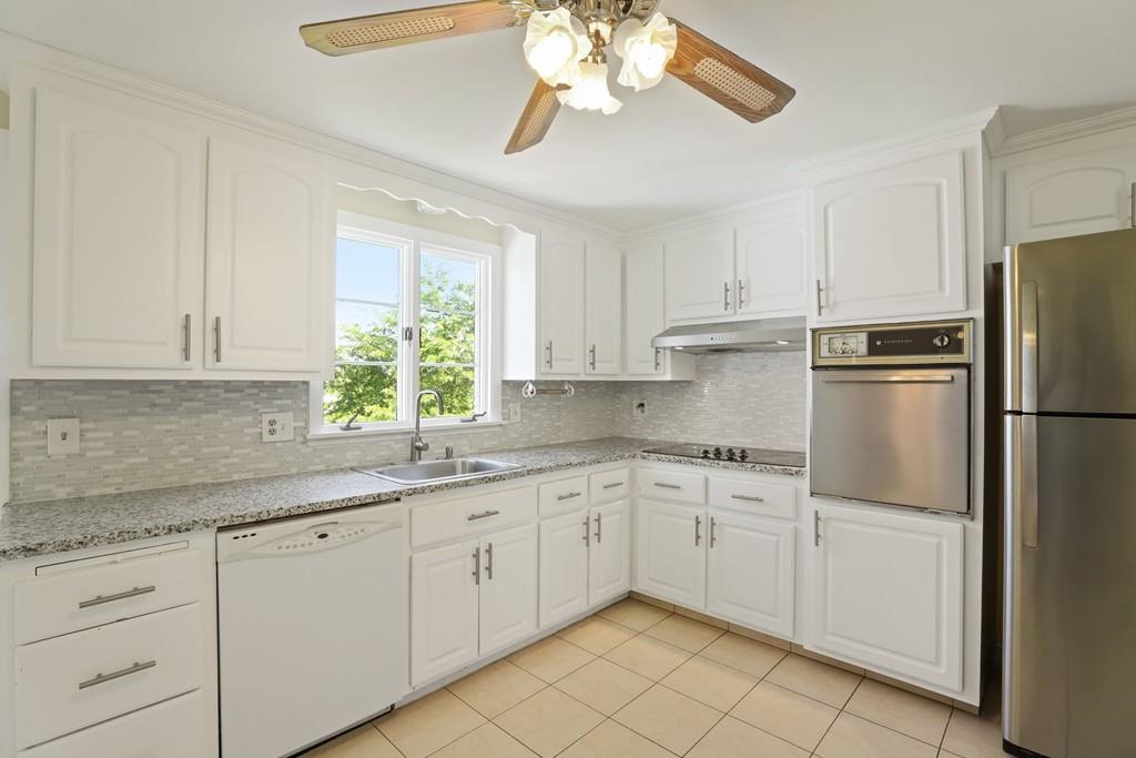 8 David Road Needham, MA 02494 - Photo 11 of 35 a kitchen with a sink dishwasher a refrigerator and cabinets