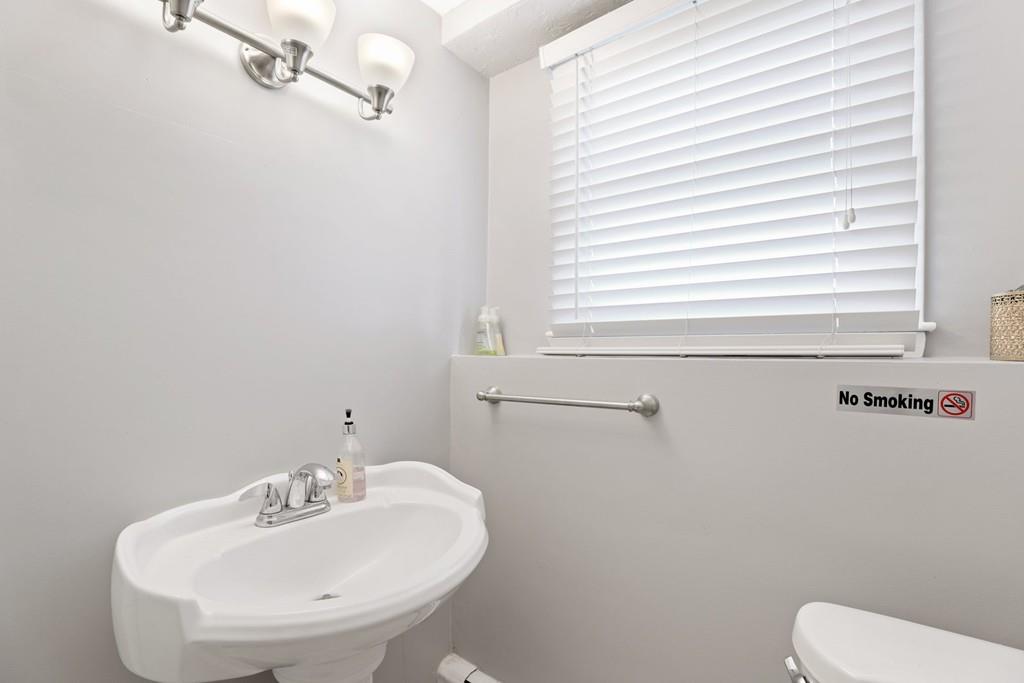 8 David Road Needham, MA 02494 - Photo 28 of 35 a bathroom with a sink a mirror and a toilet