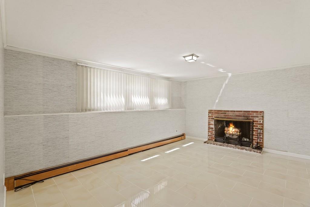 8 David Road Needham, MA 02494 - Photo 29 of 35 a view of an empty room with a fireplace and a window