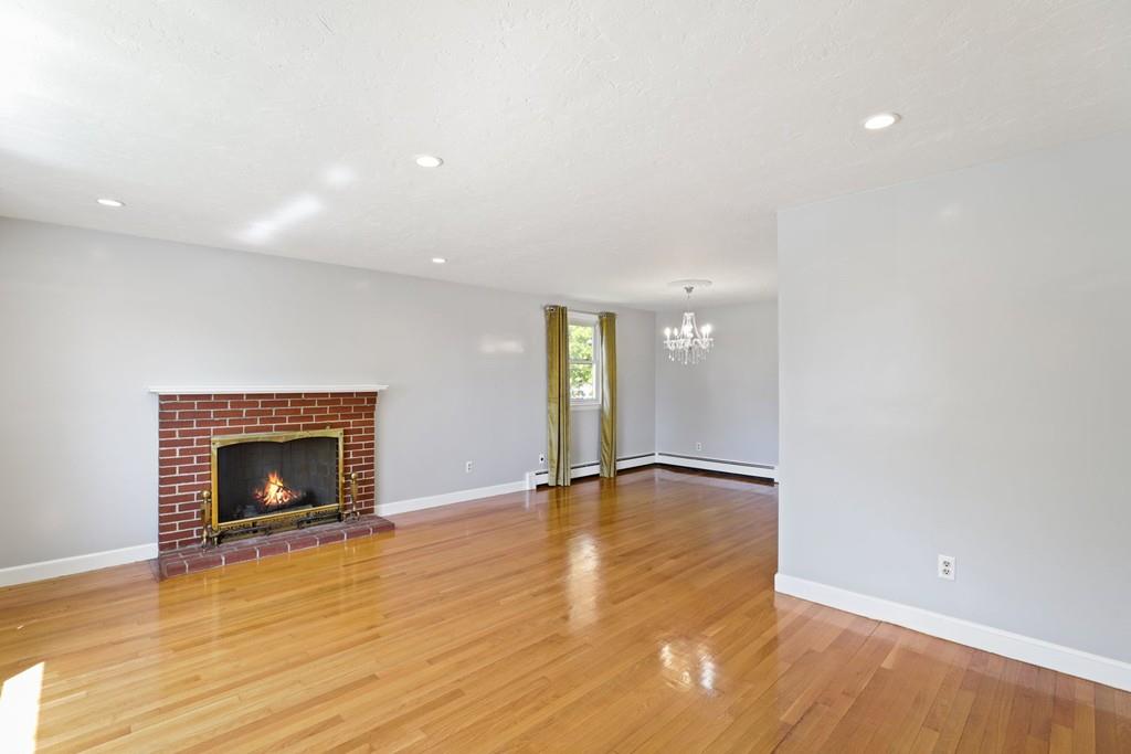 8 David Road Needham, MA 02494 - Photo 4 of 35 a view of an empty room with wooden floor and a fireplace