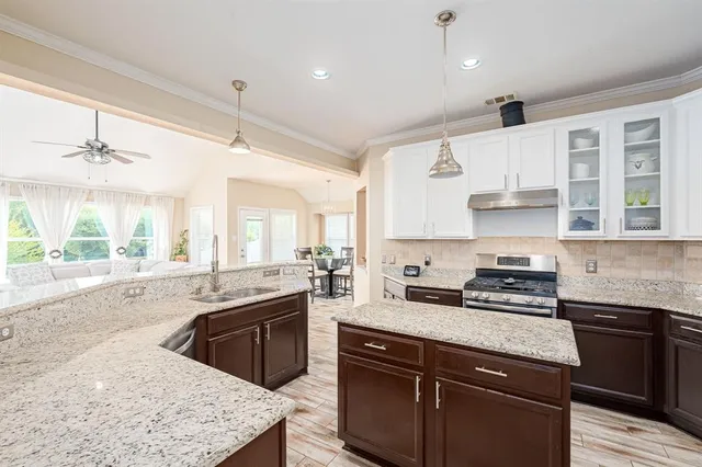 a kitchen with stainless steel appliances granite countertop a sink stove and refrigerator