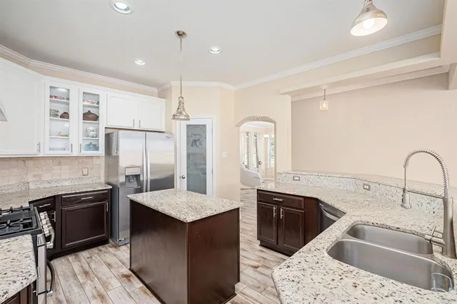 a large kitchen with kitchen island granite countertop a large counter top and stainless steel appliances
