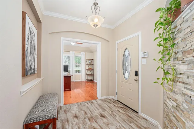 a view of a hallway with wooden floor and entryway