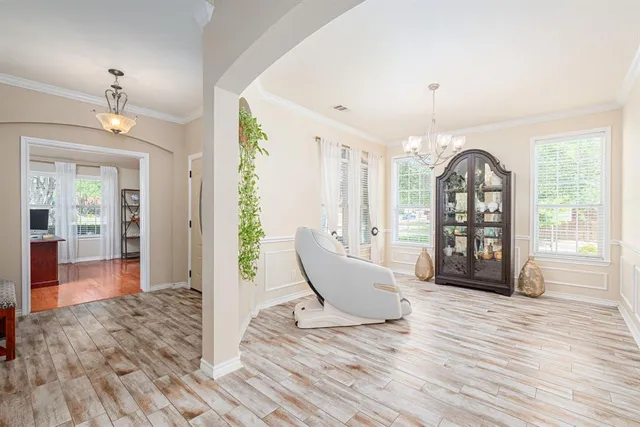 a view of a dining room with furniture a chandelier and wooden floor