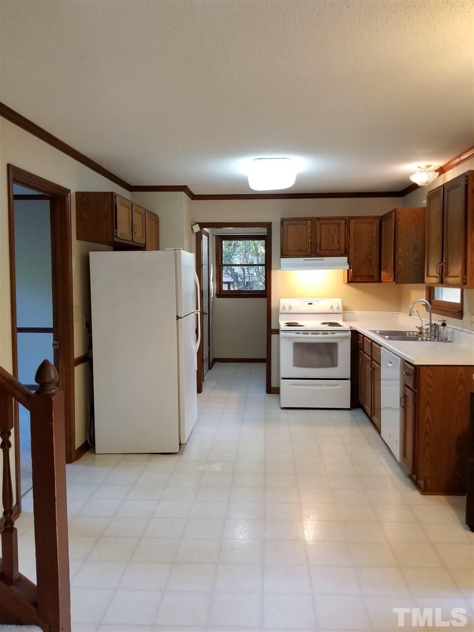 4524 Draper Road Raleigh, NC 27616 - Photo 5 of 20 a kitchen with a refrigerator and a stove top oven