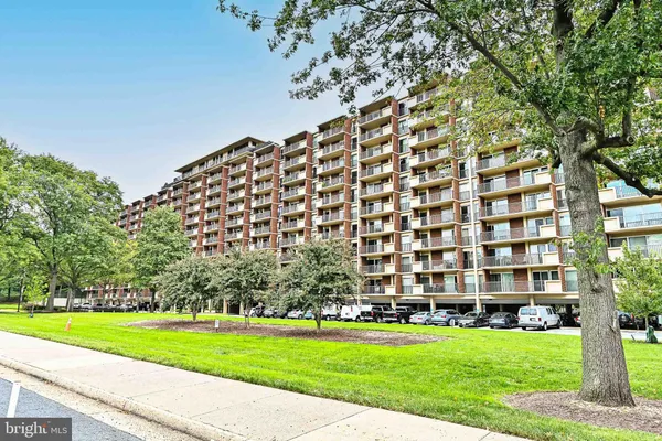a view of a big building with a big yard and large trees